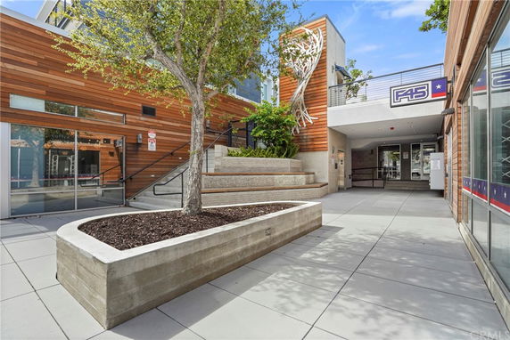 View of a commercial building entrance with wood paneling and decorative art near the doorway.