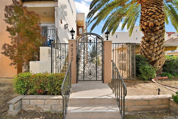 Front view of a house with an ornate metal gate and small staircase.