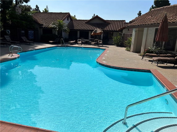 Outdoor swimming pool area with surrounding buildings.