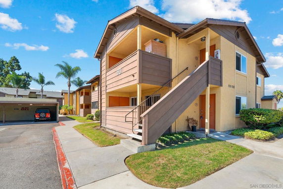 Front view of a multi-story residential building with exterior stairs and balconies.