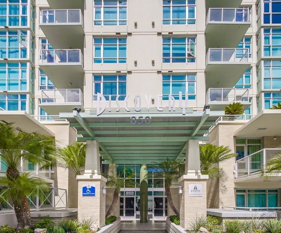 Front view of a multi-story building with balconies and large windows.