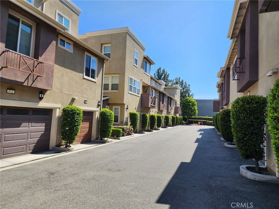 Front view of multi-story townhouses with garages and balconies.
