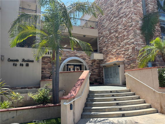 Front view of a residential building with stone facade and entrance stairs.