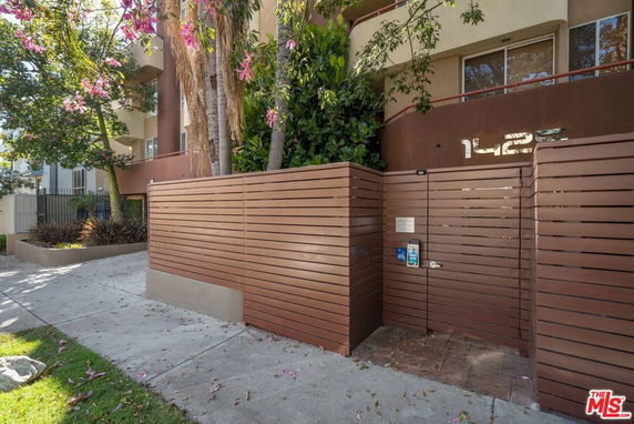 Front view of a multi-story building with a gated entrance.