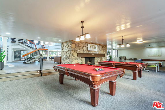 Interior view of a recreational area with pool tables and seating.