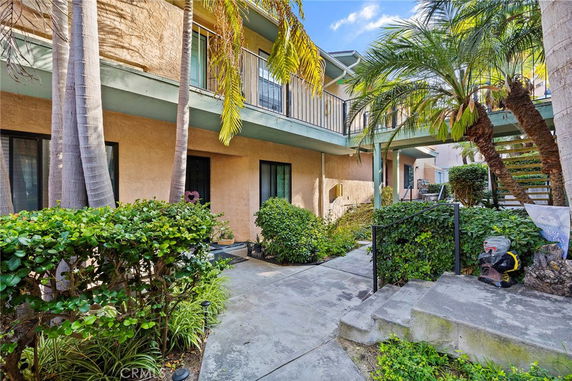 View of an apartment complex courtyard with palm trees and walkways