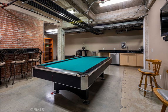 Indoor area with a pool table and bar seating.
