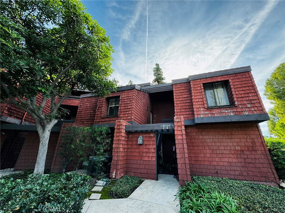 Front view of a two-story house with red shingle siding.