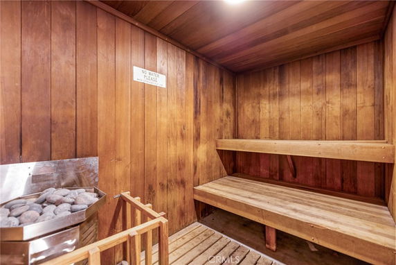 Interior view of a wooden sauna room with seating benches and a heater.