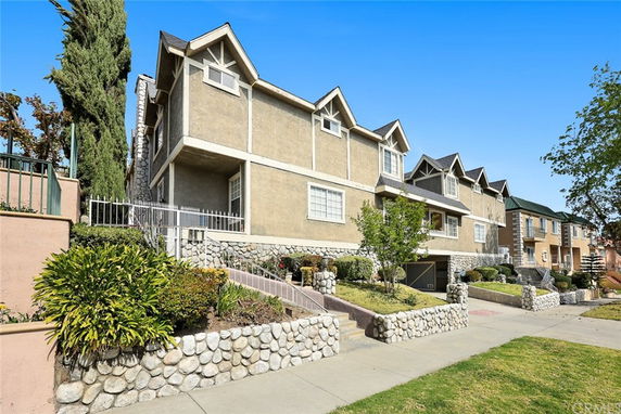 Front view of a multi-story house with stone and stucco exterior.