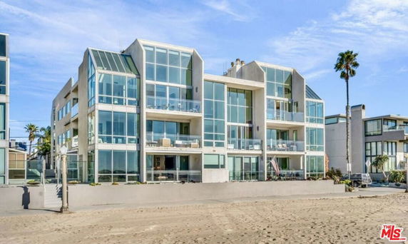 Front view of a modern multi-story building with large glass windows.