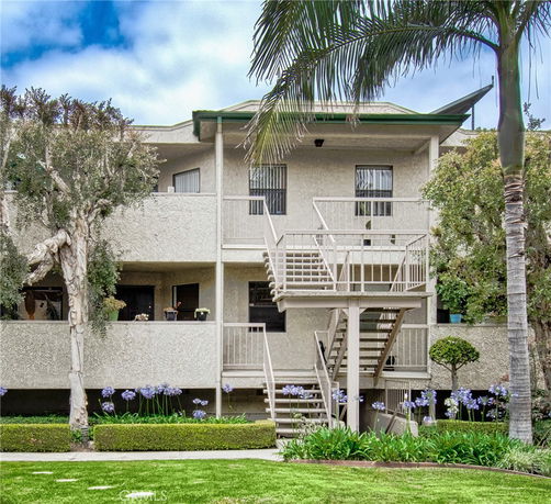 Front view of a multi-story residential building with external staircases.
