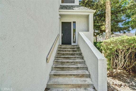 Staircase leading to the entrance of a house with a flat roof.