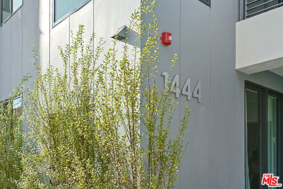 Partial view of a modern building exterior with the address number 1444.