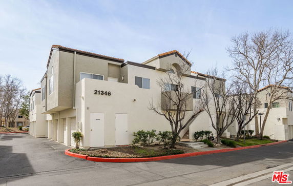 Front view of a multi-story residential building with garage spaces.