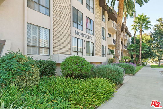Front view of a multi-story building with balconies and large windows.