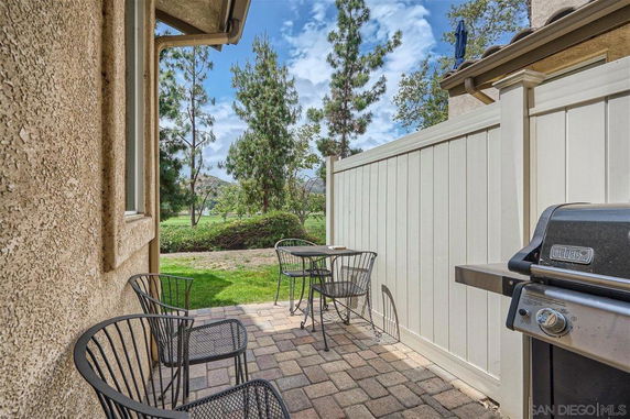 Outdoor patio area with a view of trees and a grassy field.