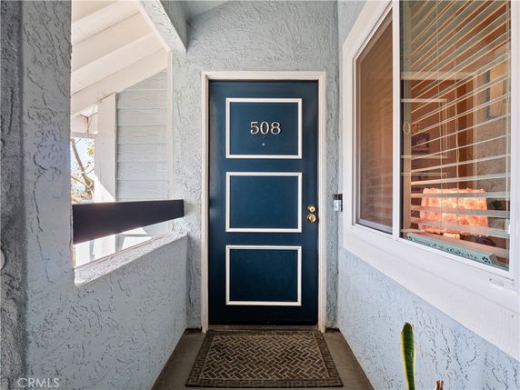 Front view of a residential entrance with a dark blue door and adjacent window.