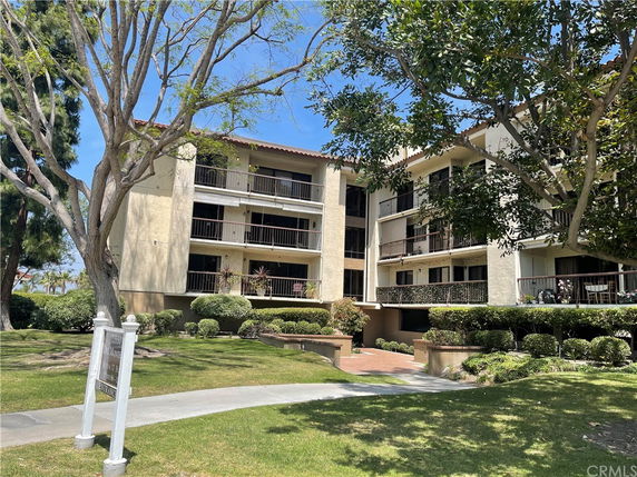 Front view of a multi-story apartment building with balconies.
