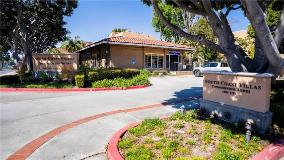 Front view of a condominium building with South Coast Villas signage.