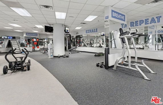Interior view of a gym with various exercise equipment and motivational signs.