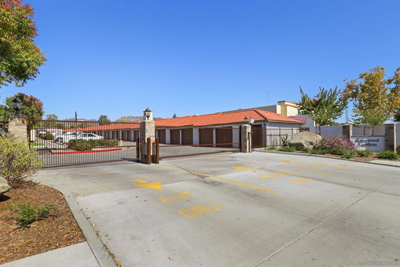 Parking area enclosed by a gated entrance with a building visible in the background.