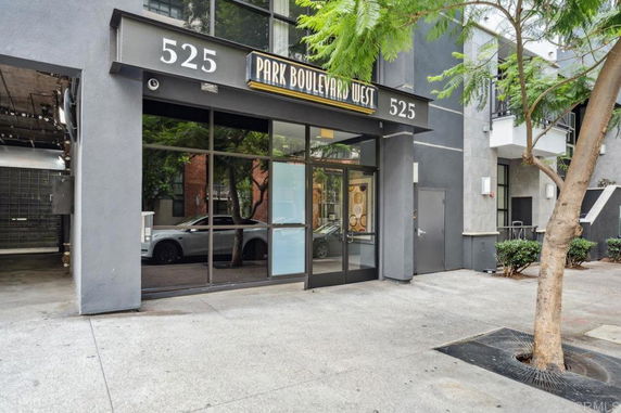 Front view of a commercial building entrance with glass doors and street number signage.