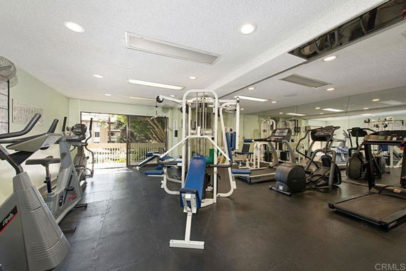 Indoor gym area with exercise equipment and mirrored walls.