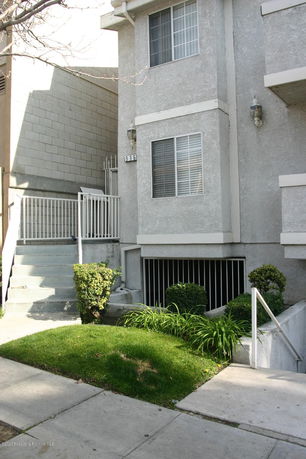 Front view of a multi-story building with windows and stairs.