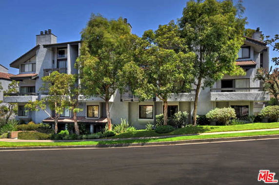 Front view of a multi-story residential building with a landscaped exterior.