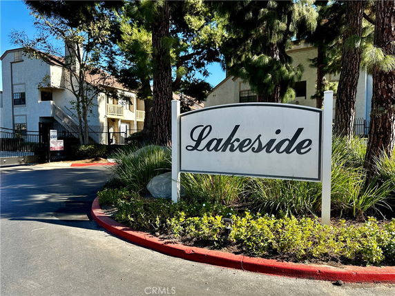Front view of a multi-story building with a gated entrance and a Lakeside sign.