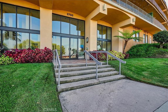 Front view of a building with large glass windows and entrance steps.