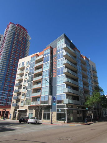 Front view of a modern multi-story apartment building with balconies.