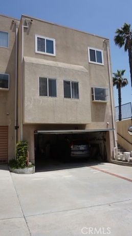 Front view of a multi-story building with open garage.