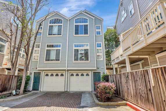 Front view of a multi-story townhouse with a double garage.
