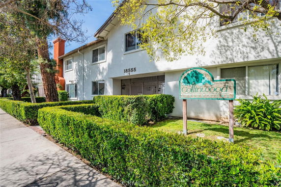 Front view of a two-story condominium building with white exterior and signage reading 'Collinwood Condominiums'.