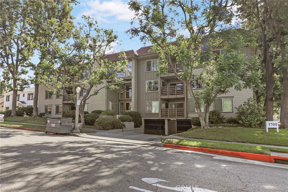 Front view of a multi-story apartment building with balconies.