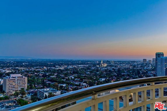 Panoramic view from a building overlooking a cityscape during sunset.