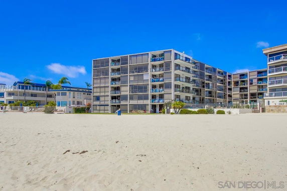 Front view of a multi-story beachfront building with balconies.