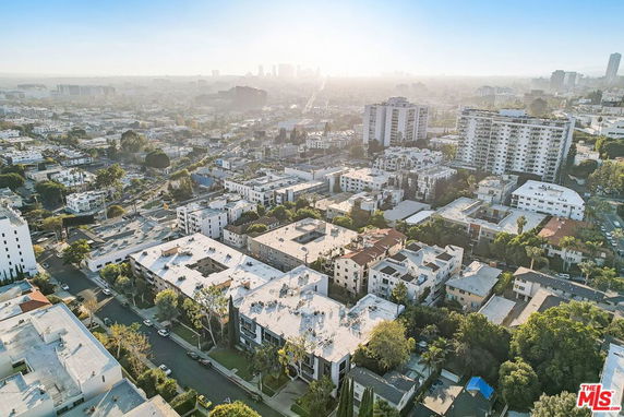 Aerial panoramic view of an urban area with multiple multi-story buildings and a cityscape in the background.