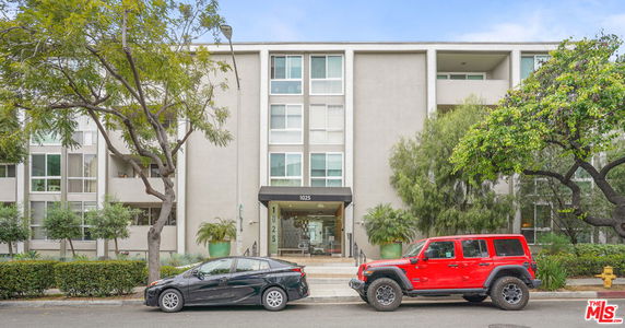 Front view of a multi-story building with a modern design and balconies.