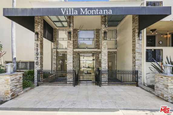 Front view of a building entrance with a sign reading 'Villa Montana' and decorative stone columns.