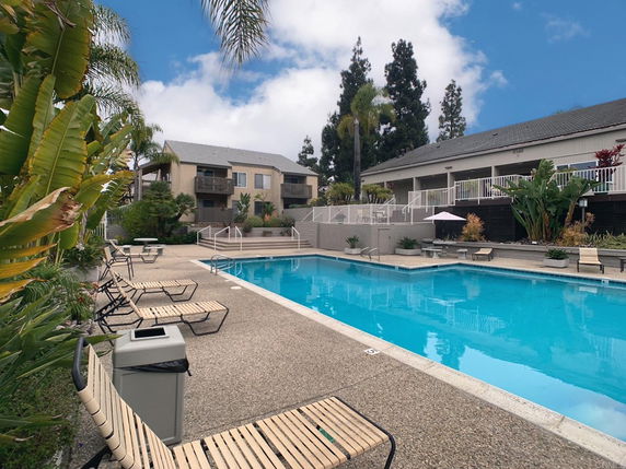 Outdoor swimming pool area with adjacent residential buildings.