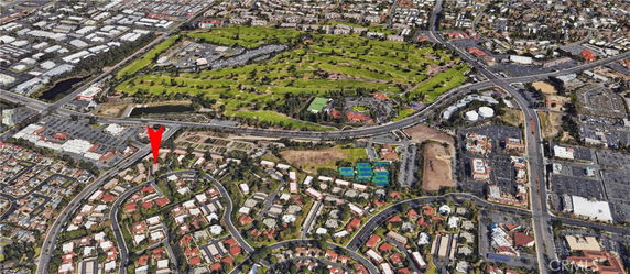 Panoramic view of a residential area with roads and a golf course.