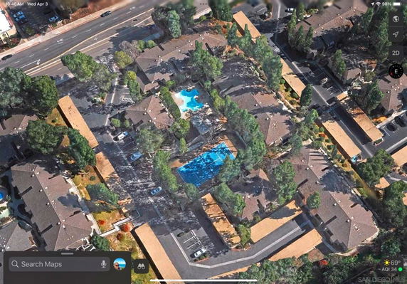 Aerial view of a residential complex with multiple buildings and swimming pools.