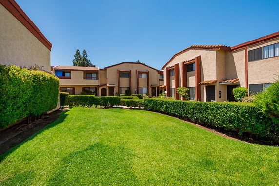 Front view of a multi-story building with a landscaped lawn.
