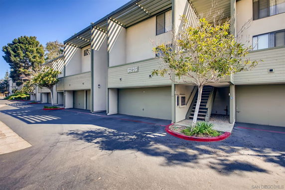 Front view of a multi-story residential building with ground-level parking.
