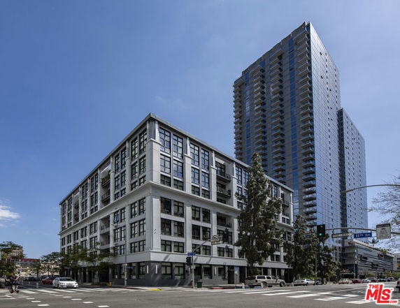 Front view of a multi-story building and a high-rise tower.