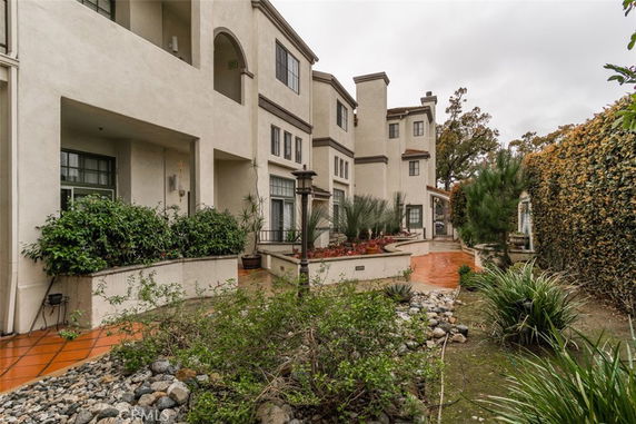 Front view of a multi-story townhouse complex with a garden path.
