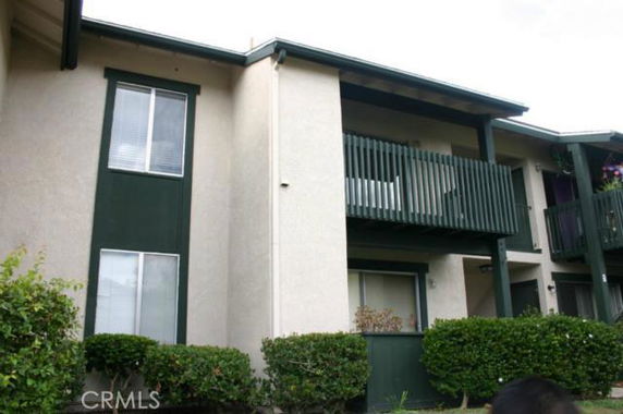 Front view of a two-story building with balconies and green trim.